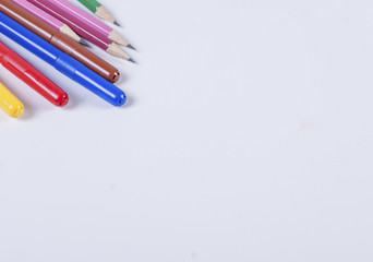Multi-colored felt-tip pens and pencils on a white background