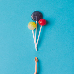 Doll hand with lollipops. Minimal concept. Flat lay.