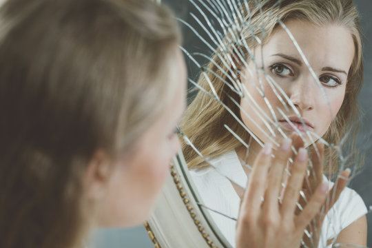 Woman Touching Broken Mirror