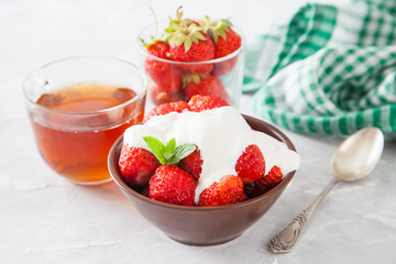 strawberry with sour cream in a bowl on a table, selective focus