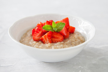 porridge with strawberry on a table, selective focus