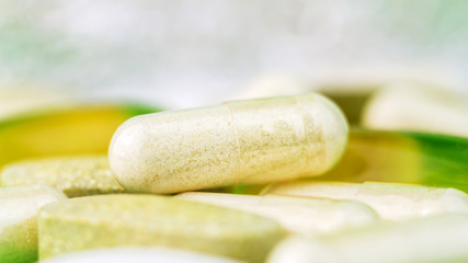Mixed natural food supplement pills, omega 3, multivitamin and glucosamine capsules, macro image.