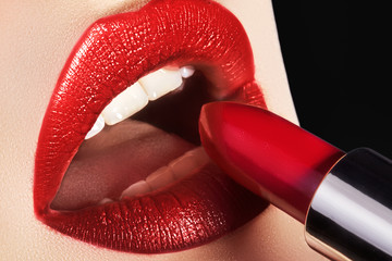 Obraz premium Close-up of woman's lips with fashion red make-up. Beautiful female mouth, full lips with perfect makeup. Part of female face. Macro shot of beautiful make up on full lips. Choice lipstick