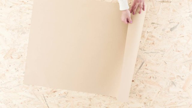 Video with woman unrolling blank sheet of paper
