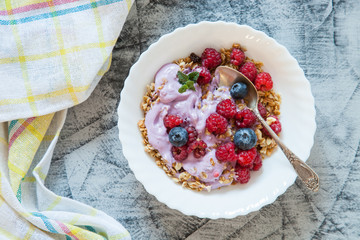 yogurt and muesli with berries on a table, selective focus, top view