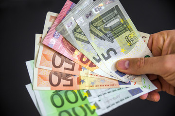 Man hand with euro isolated on black background, Hand holding euros