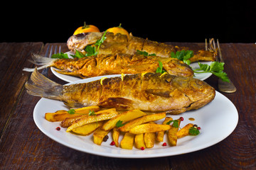 fried fish on a white plate on a wooden background