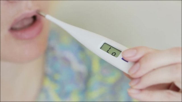 Sick ill woman with digital thermometer in mouth.