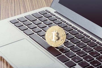 Golden bitcoin physical coin symbol on keyboard