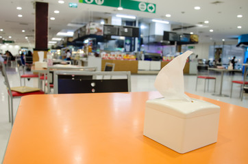 White Tissue Box on the Orange with Blur Food Court Background Wallpaper.Free Tissue for Clean Table and Cleand People Who Eating Food.