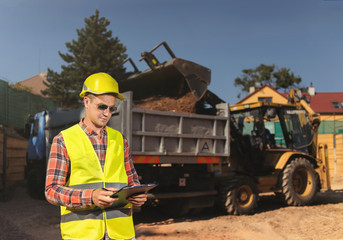 Construction worker writes the clipboard data. construction background.