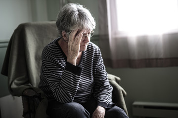 worried senior woman at home felling very bad