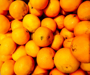Fresh organic tangerine stand out among many large background tangerines in the market. Fruit of...