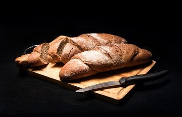 Close up of the baguette lying on a black background