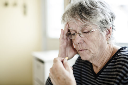 Sick Senior Woman Taking Her Pills At Home