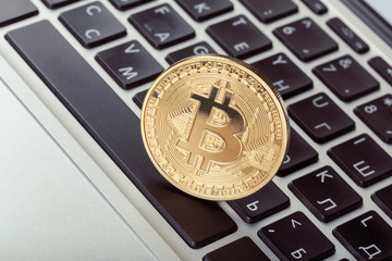 Golden bitcoin physical coin symbol on keyboard
