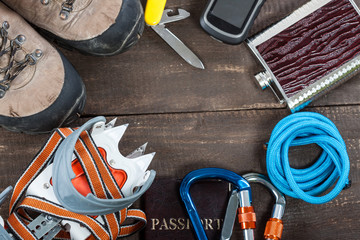 Equipment for mountaineering and hiking on wooden background.