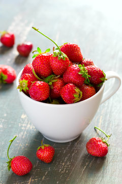 White cup with ripe garden strawberries closeup