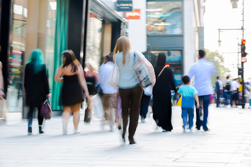 Obraz premium Zamazany obraz chodzących ludzi. Londyńczycy i turyści spacerujący po Oxford Street, jednym z głównych miejsc zakupów w Londynie