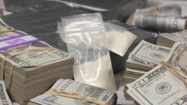 Drugs and cash money everywhere on a table. Closeup shot.