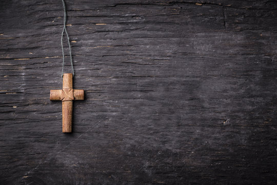 Brown cross on a black wooden background