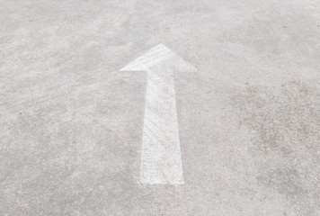Closeup surface old and pale white painted arrow sign on cement street floor textured background