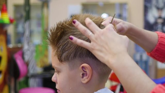 haircut of a child with scissors in the barbershop