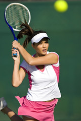 Female tennis player hits ball 