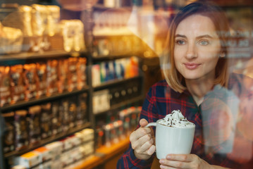 Portrait of beautiful woman setting in cozy cafe and drinking flavored coffee, Hipster girl wearing a shirt enjoying coffee after autumn walk, Autumn mood, Christmas mood