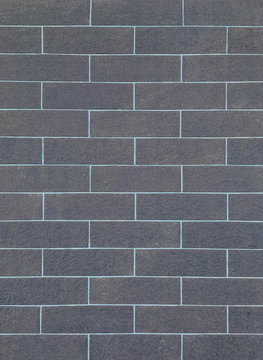 Closeup surface brick pattern at old black stone brick wall textured background