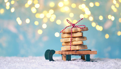 selbstgebackene Plätzchen für Weihnachten auf einem Schlitten im Schnee - obrazy, fototapety, plakaty
