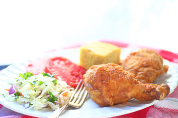 Fried chicken with coleslaw, tomatoes and cornbread with room for text