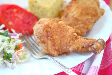 Fried chicken with coleslaw and cornbread with fork