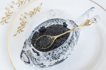  Beautiful bowl with black caviar on beautiful white plate