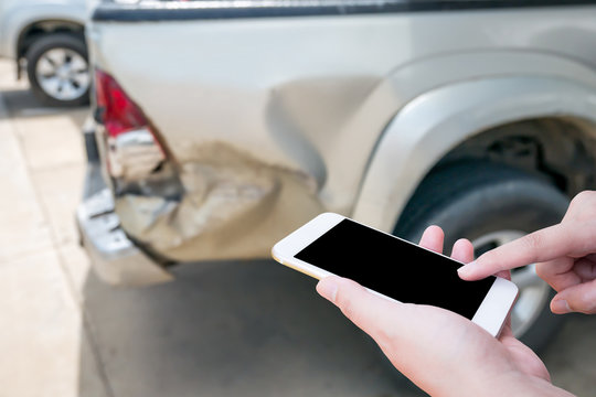 Female using mobile phone after car accident