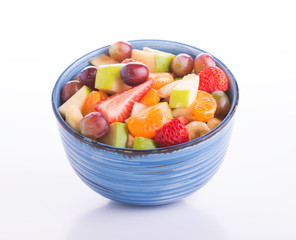 Colordul fruit salad in a blue ceramic bowl, on light background - Powered by Adobe
