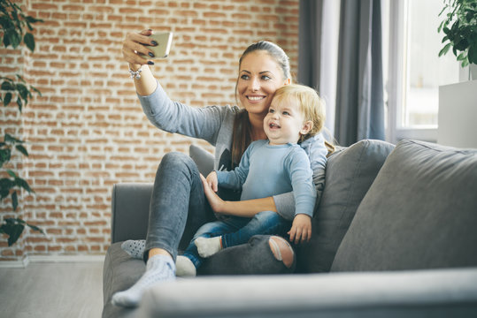 Mom And Toddler Taking Selfie In Cosy Living Room