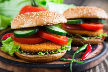 Fishburger with vegetables on a bun with sesame seeds