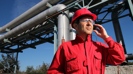 Industrial Worker With Cell Phone / Worker with personal protective equipment using cell phone  in...