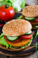 Fishburger with vegetables on a bun with sesame seeds
