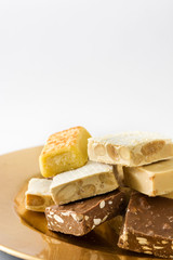 Christmas nougat on a golden plate isolated on white background
