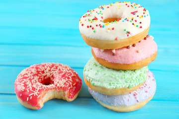 Stack of delicious donuts on blue wooden background