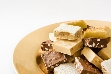 Christmas nougat on a golden plate isolated on white background

