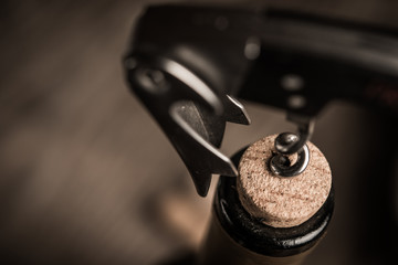 Corkscrew screwed into the cork in the bottle of wine