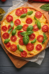 Fresh tasty pizza Margarita on wooden tray, top view