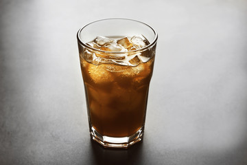 Glass of iced coffee on grey background