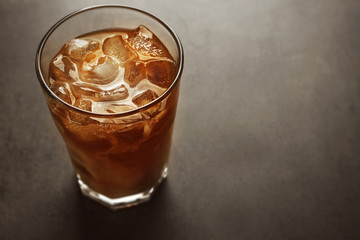 Glass of iced coffee on grey background