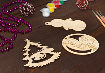 Christmas gifts handmade on wooden table . Piece of wood in the form of Snowman , Christmas tree and Cockerel for gifts before painting.