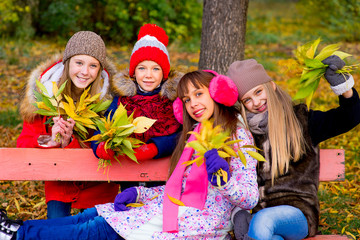 Fototapeta premium group of girls in autumn park with leafs