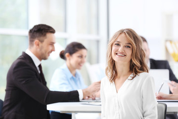 Businesswoman with colleagues on background at office
